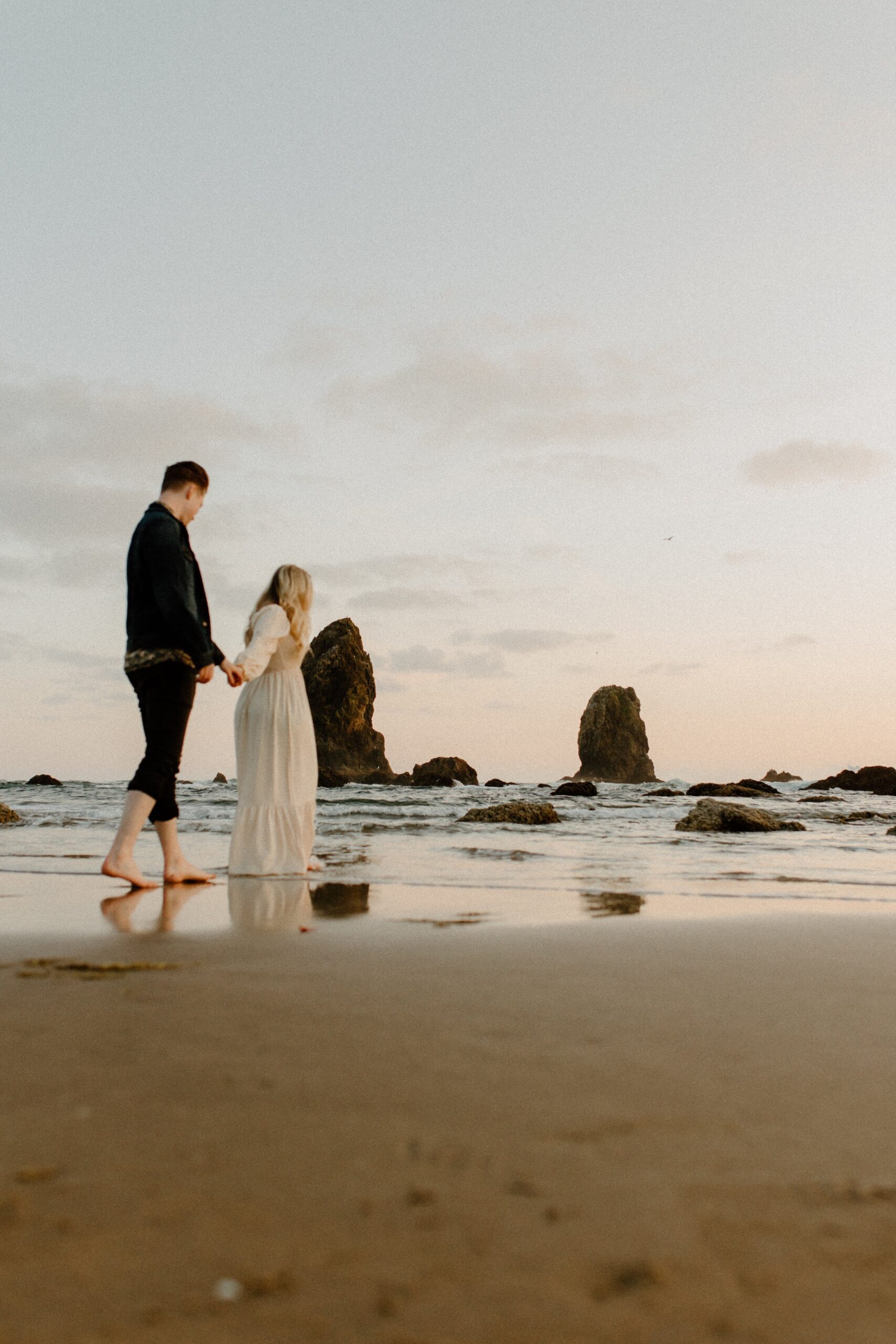 couple holding hands while walking on the beach in Oregon, film photographer