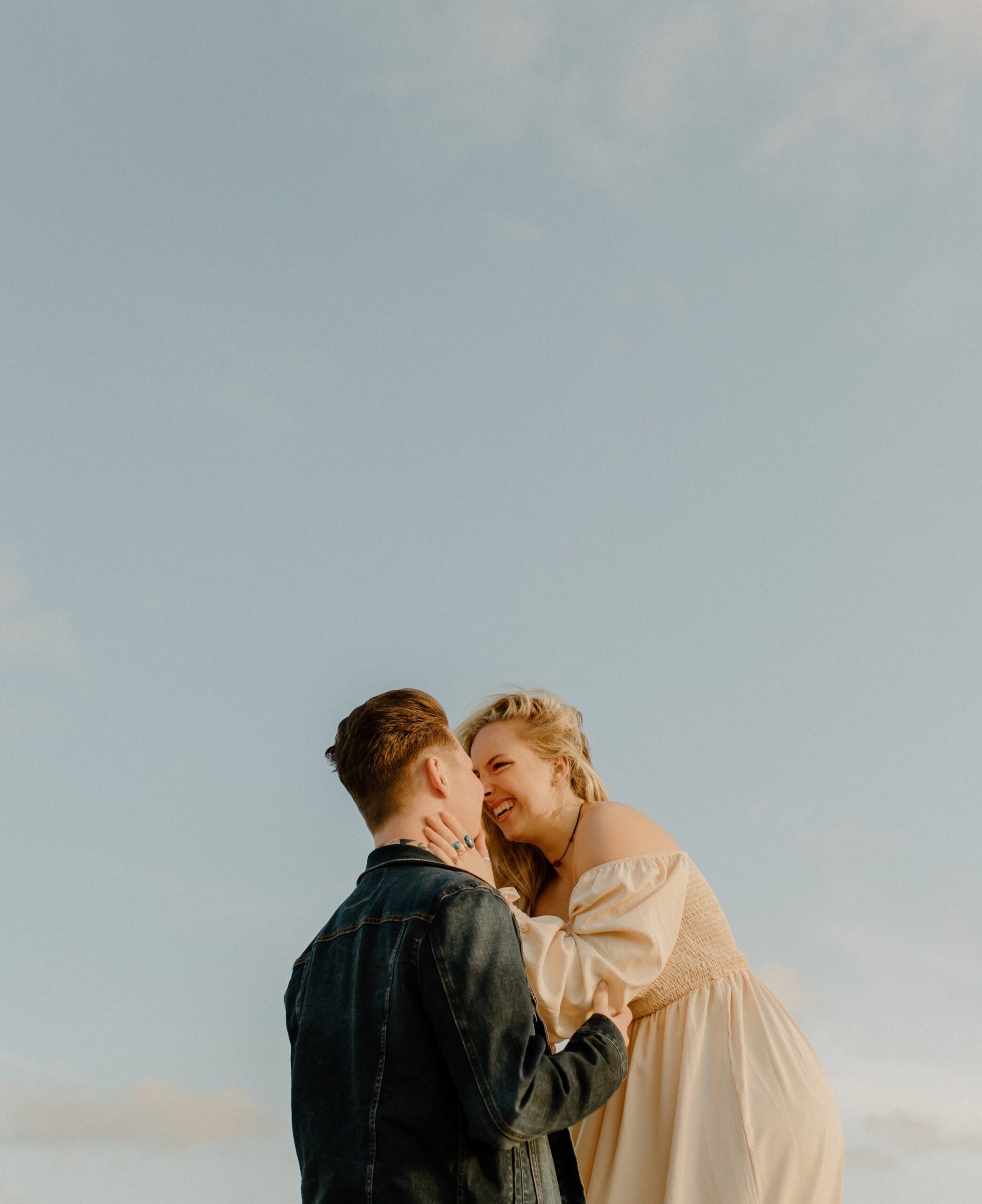Man and woman looking into each other's eyes with background of blue skies