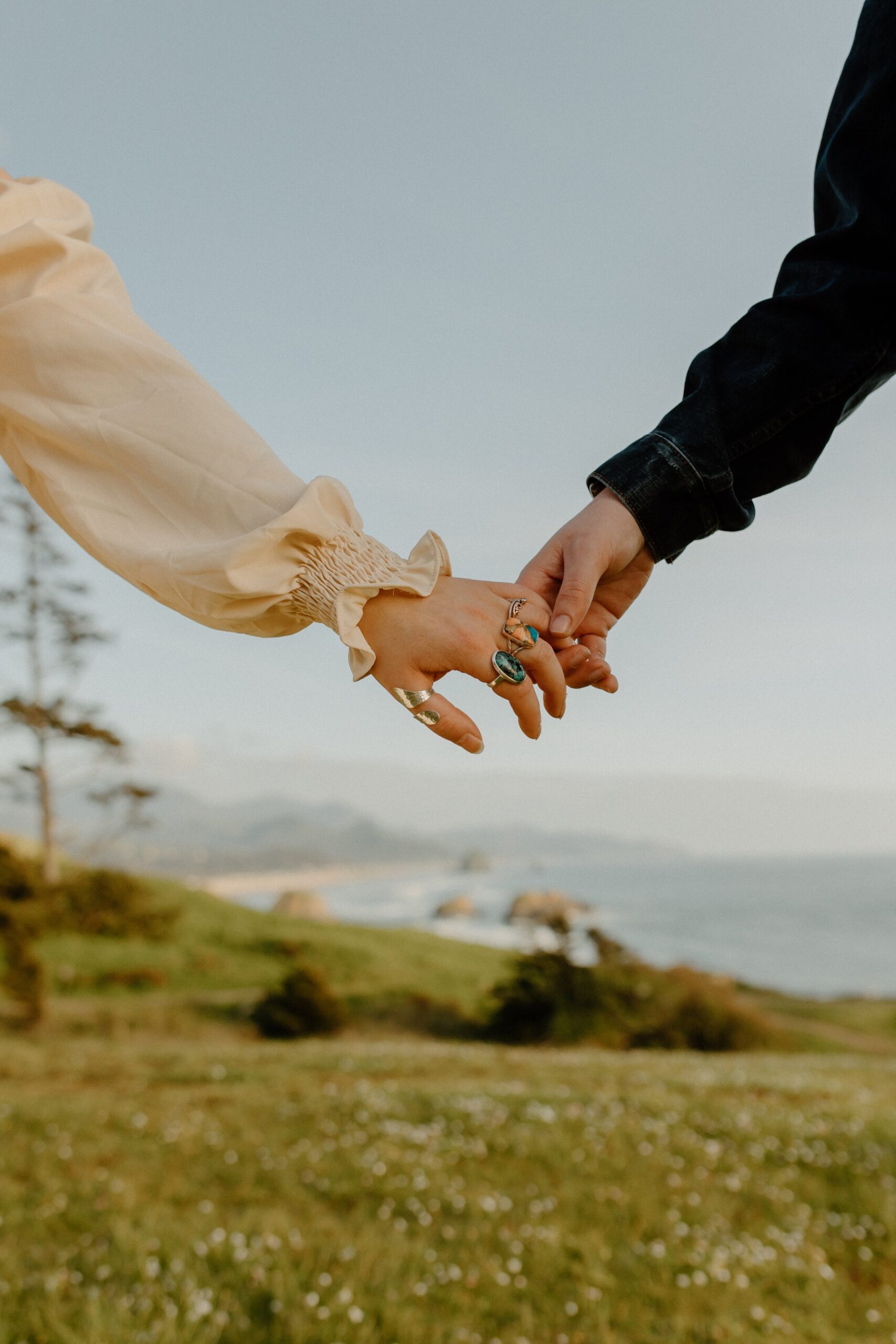 man and woman holding hands with background of blue skies