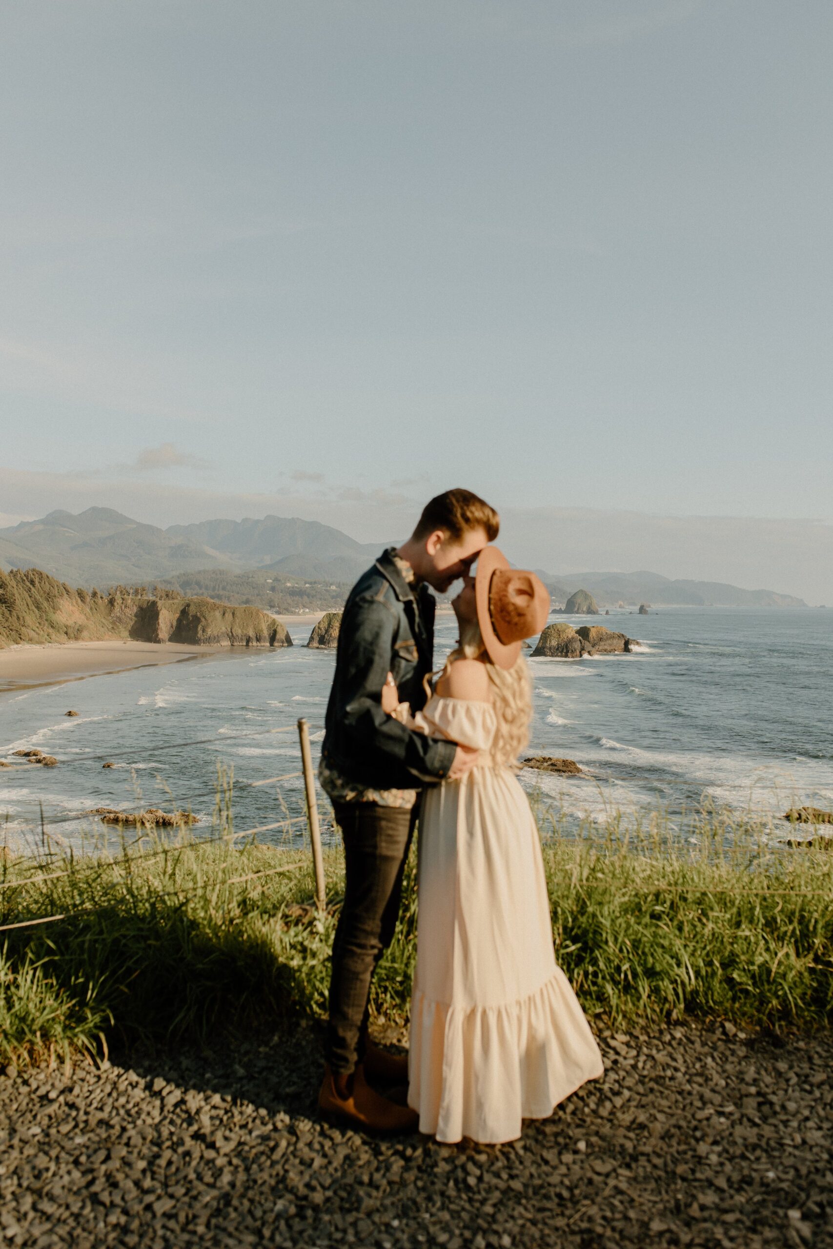Man kissing woman on cliff near beach