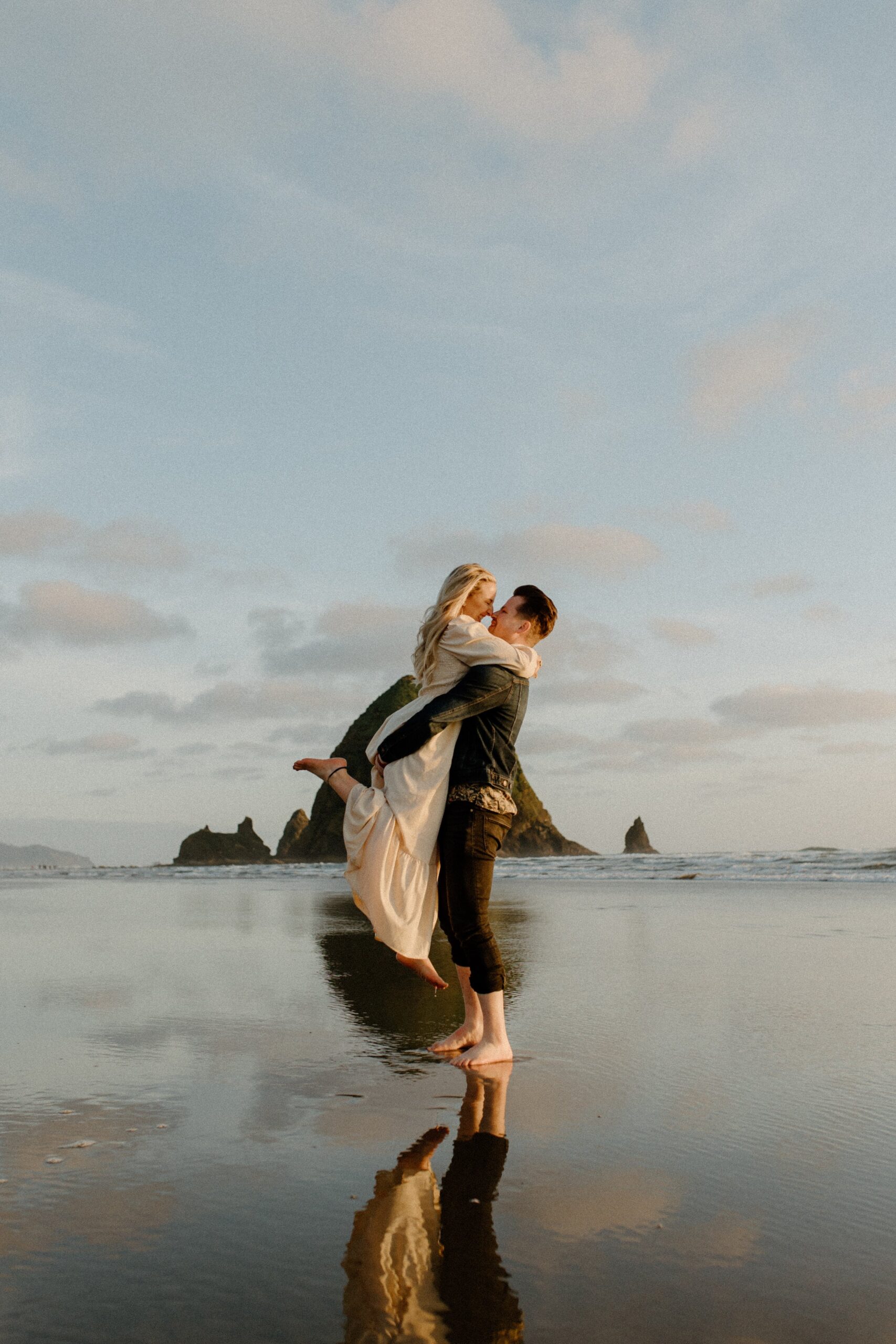  man holding woman in air while standing on the beach in Oregon, Oregon film photography 