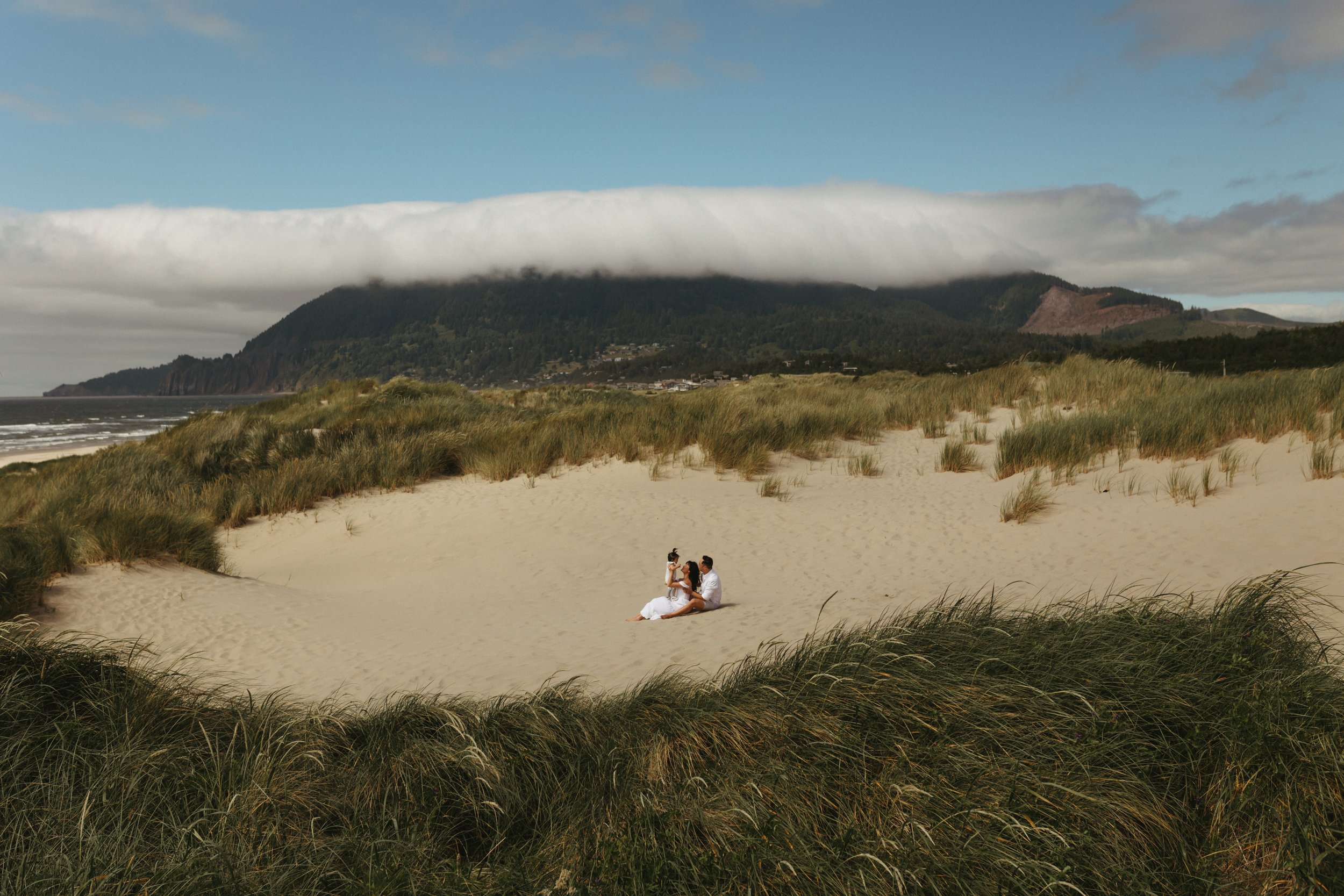 non traditional family photos on the oregon coast wearing white in sand banks