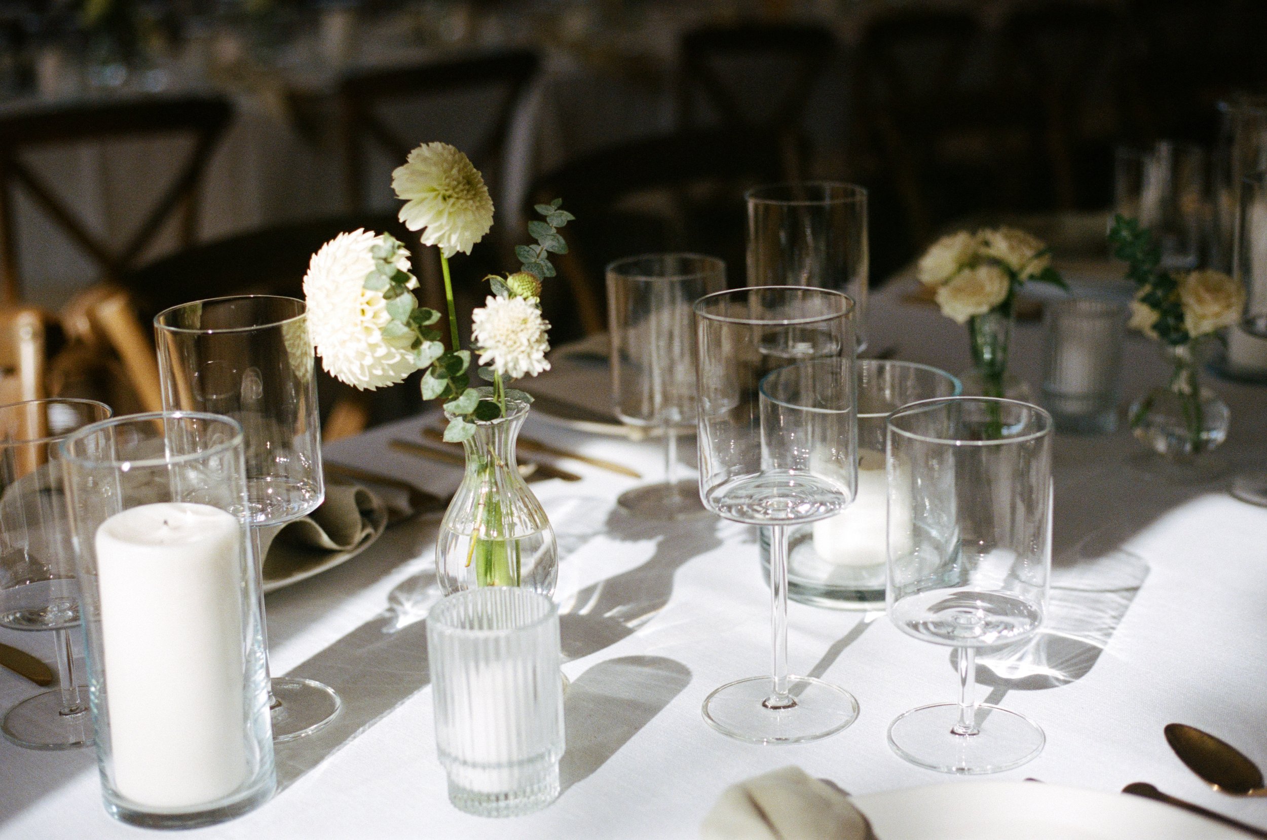 dahlia wedding flower centerpieces surrounded by wedding table decorations. Oregon coast wedding film photography