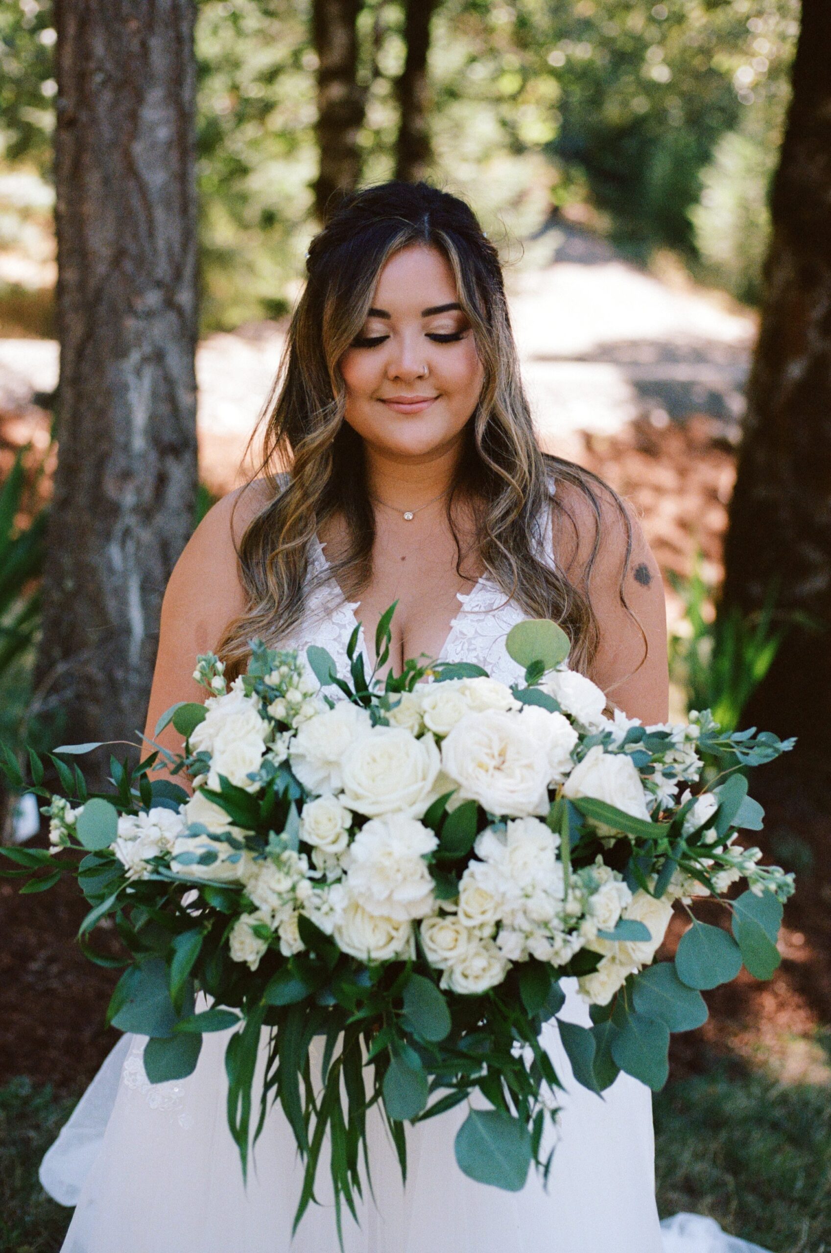 bride posing while holding wedding flower bouquet and closing her eyes. wedding photography in oregon, wedding film photos