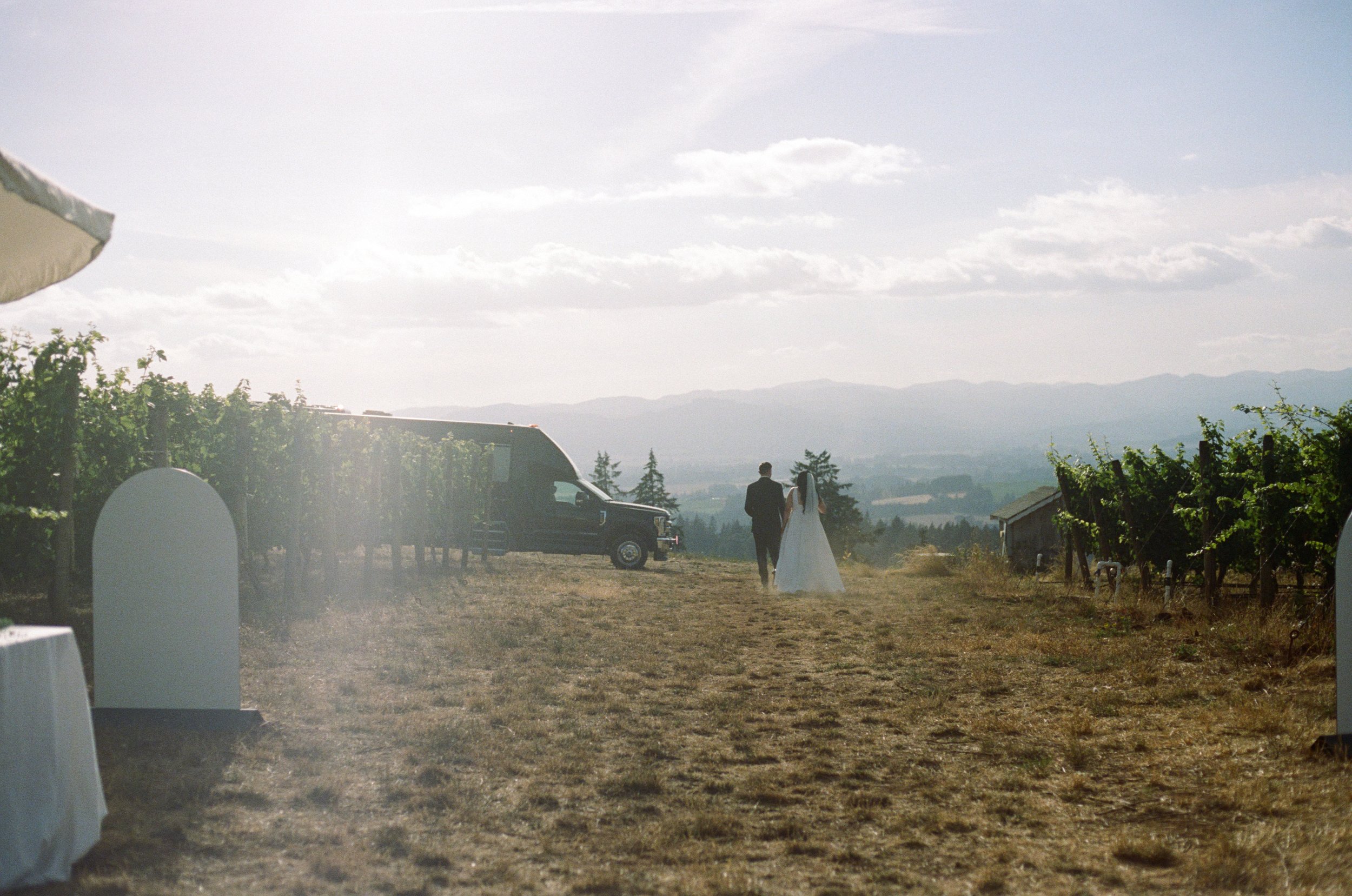 film photo of bride and groom walking off into distance after their wedding ceremony. Film photography in Oregon, wedding photographer in Portland