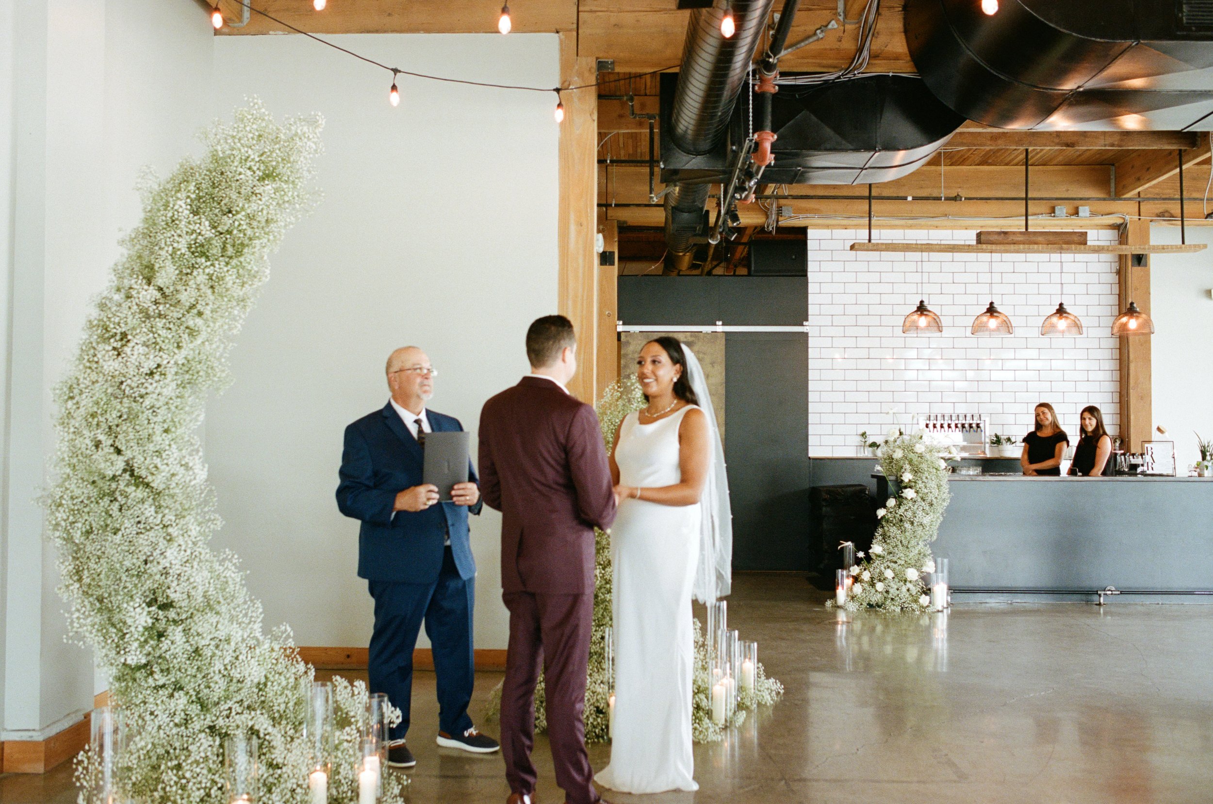 indoor wedding ceremony with bride and groom holding hands. Wedding photos on film