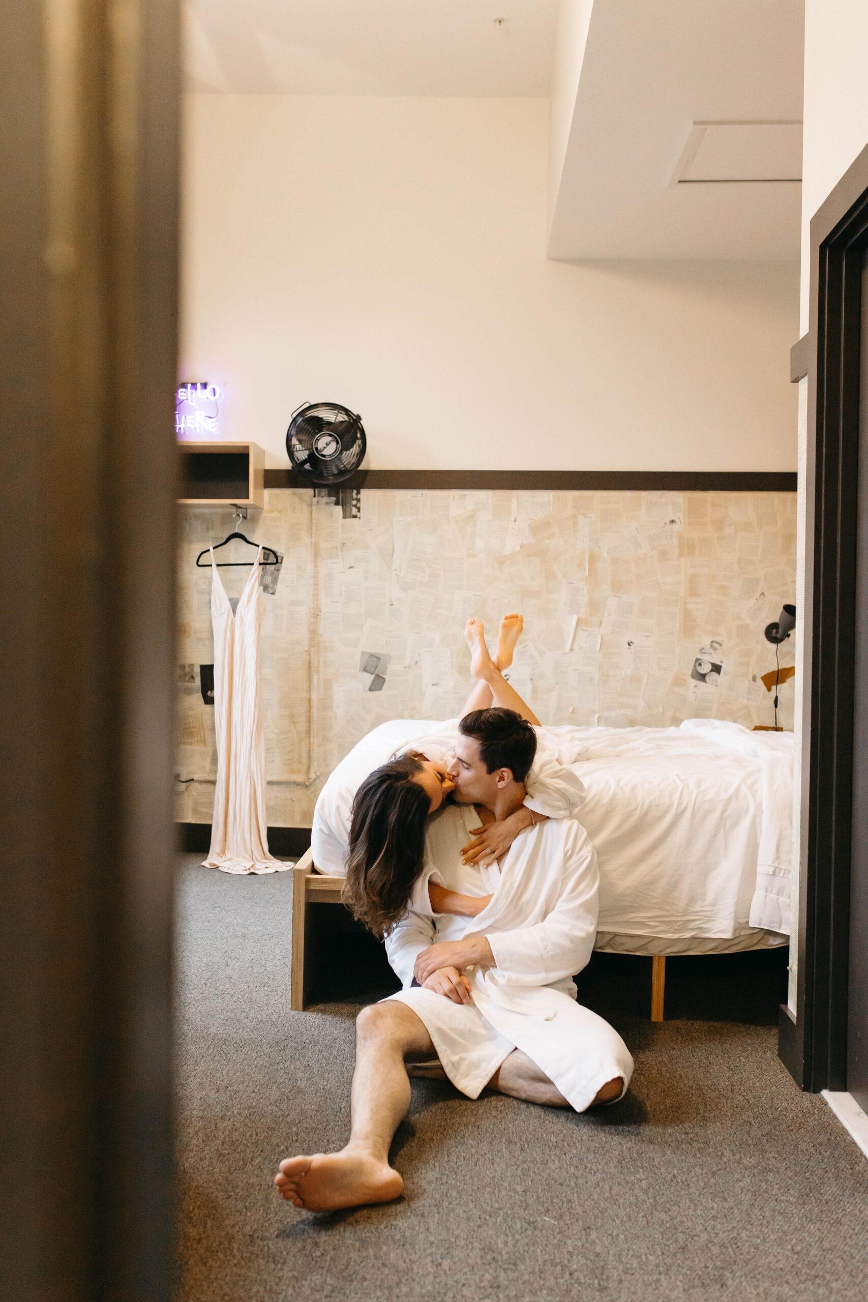  Couple in white robes in hotel room getting ready together on their wedding day 