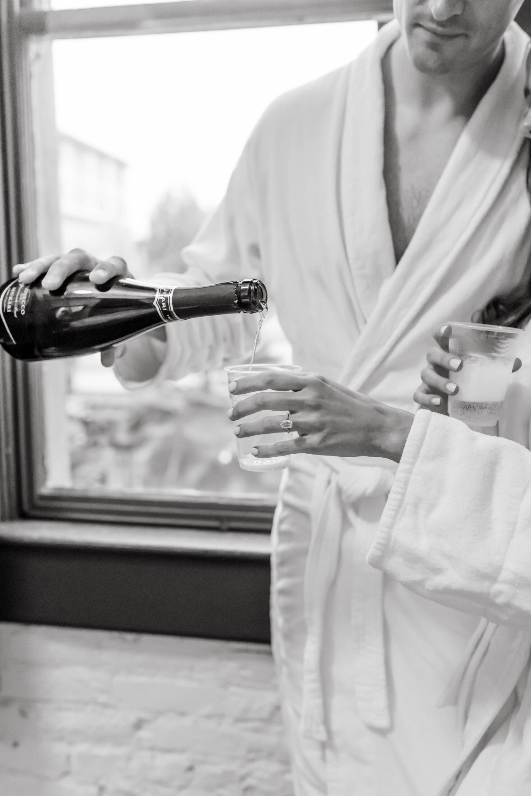  Couple in white robes in hotel room getting ready together on their wedding day 