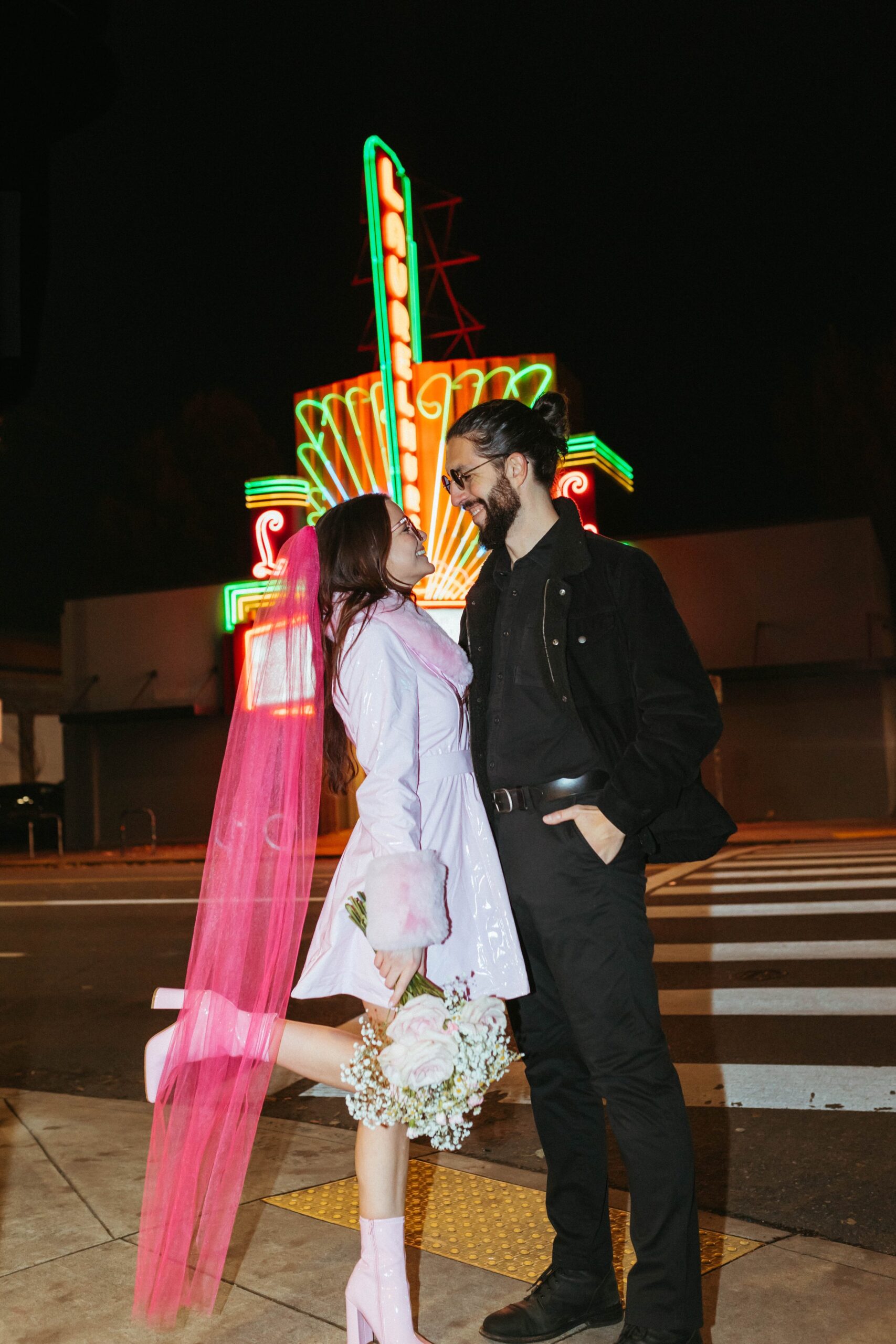  funky, modern, engagement photoshoot, neon signs, fun earrings, the unique couple poses, vegas inspired elopement nasty gal two-piece set, colorful suit, pearl gloves, movie theater, vintage, retro 