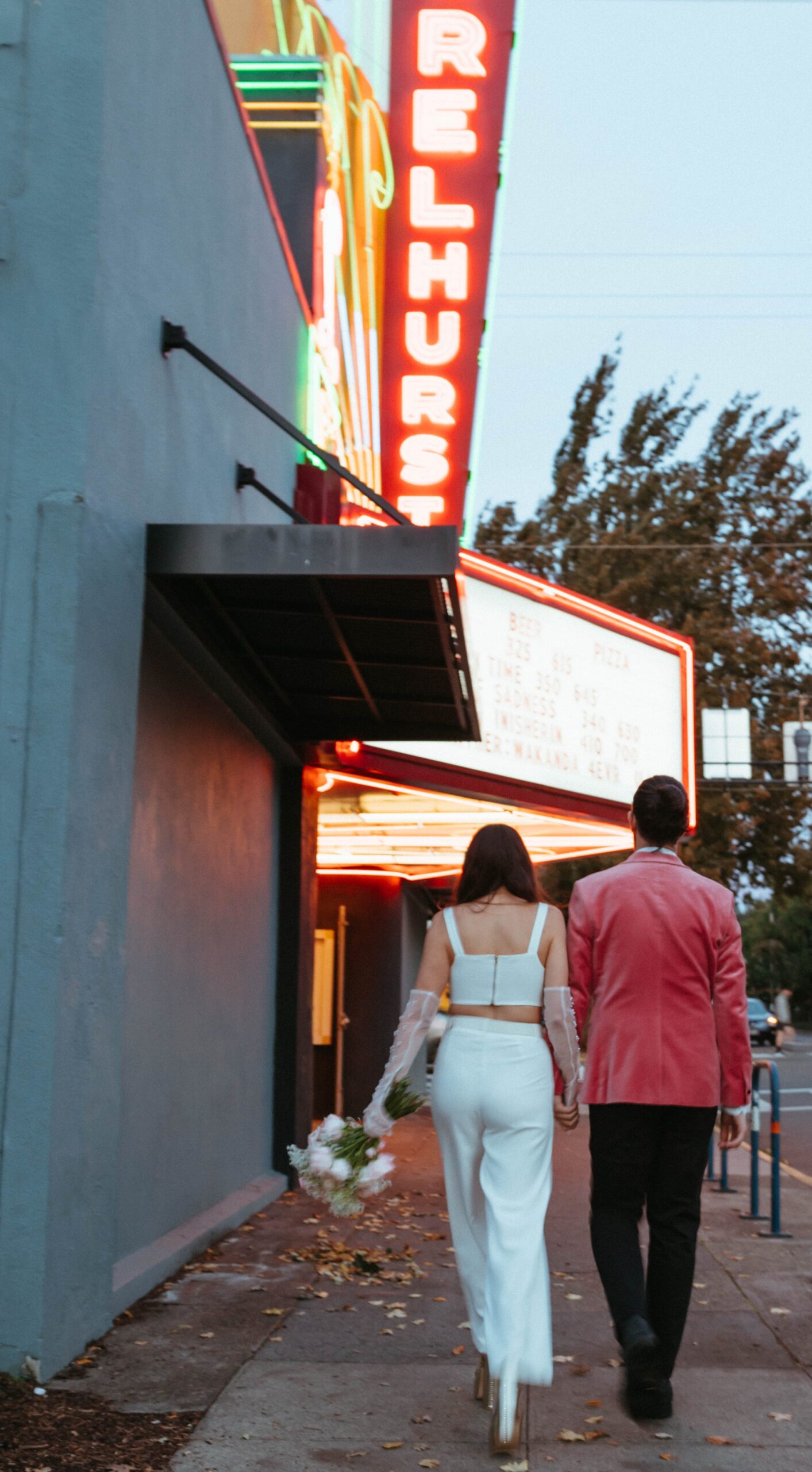  funky, modern, engagement photoshoot, neon signs, fun earrings, the unique couple poses, vegas inspired elopement nasty gal two-piece set, colorful suit, pearl gloves, movie theater, vintage, retro 