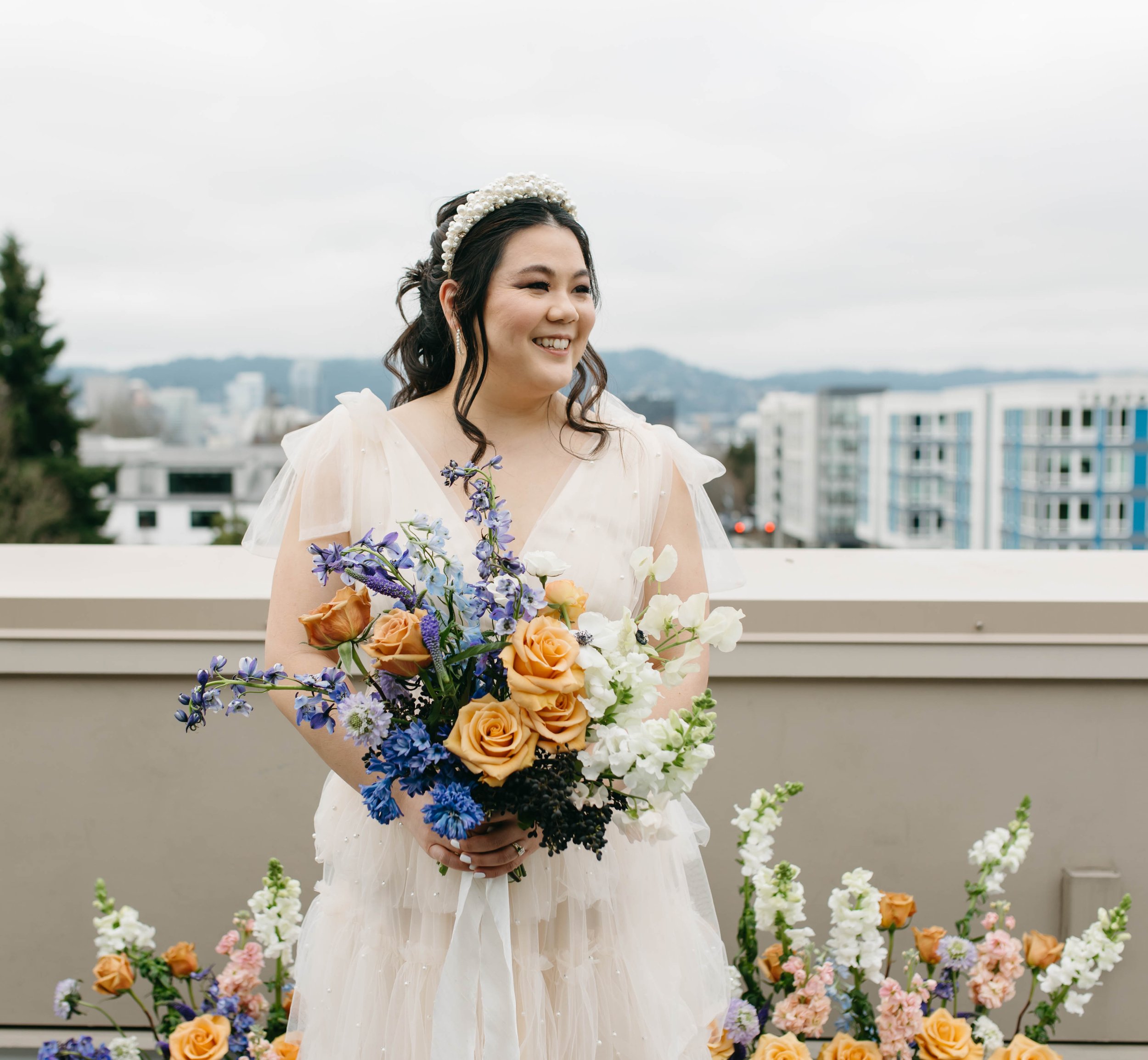  colorful whimsical small wedding elopement in Portland, Oregon. Lolo pass hotel. Purple, blue, and orange floral arrangement, fine china, beautiful place setting, private rooftop vows 